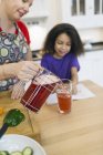 Mother serving glass of juice to daughter — Stock Photo