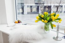 Fur rug and flower vase — Stock Photo