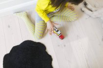 Девушка играет с игрушечными машинами — стоковое фото