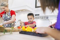 Мама з дітьми нарізає овочі — стокове фото