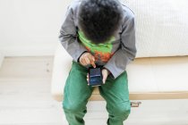 Garçon jouer à des jeux sur téléphone intelligent — Photo de stock