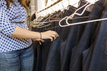 Frau wählt Jeans in Fabrik — Stockfoto