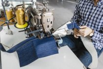 Tailor sewing jeans — Stock Photo