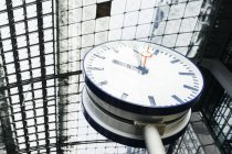 Часы под стеклянным потолком железнодорожного вокзала — стоковое фото