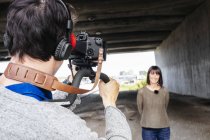 Camarógrafo filmando reportero de noticias - foto de stock