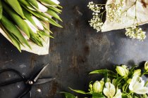 Flores con tijeras en la mesa - foto de stock