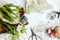 Flowers and photographs on table — Stock Photo