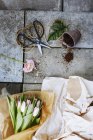 Bouquet di tulipani con forbici e pentola sul pavimento di cemento — Foto stock