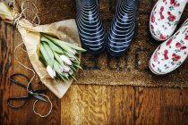 Gardening boots by tulip bouquet — Stock Photo