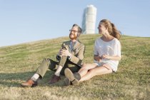 Casal sentado no monte gramado — Fotografia de Stock