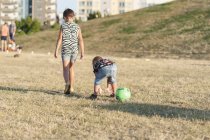 Brother and sister on grassy field — Stock Photo