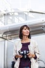 Женщина держит цифровую камеру — стоковое фото