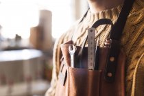 Carpenter with work tools in apron pocket — Stock Photo