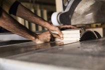 Carpenter cutting wood using table saw — Stock Photo