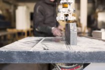 Плотник с помощью бензопилы в мастерской — стоковое фото