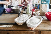 Dough in baskets with family in background — Stock Photo