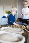 Brothers baking cookies at home — Stock Photo
