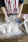 Épousseter la farine à la main sur la pâte — Photo de stock