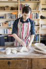 Пекарь месит тесто за столом — стоковое фото