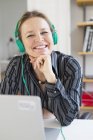 Mulher de negócios usando fones de ouvido no escritório — Fotografia de Stock