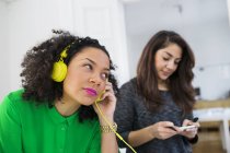 Businesswoman in headphones and colleague holding note — Stock Photo