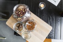 Hazel nuts and chili flakes on cutting board — Stock Photo