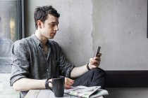 Человек с помощью мобильного телефона в кафе — стоковое фото