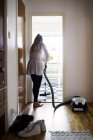 Жінка прибирає підлогу з пилососом — стокове фото