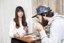 Homme jouant aux cartes avec petite amie — Photo de stock