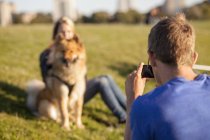 Homme photographier petite amie et chien — Photo de stock