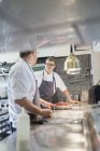 Chefs comunicando na cozinha comercial — Fotografia de Stock