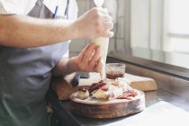 Chef using icing bag in kitchen — Stock Photo