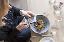 Woman photographing food — Stock Photo