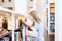 Young woman choosing books — Stock Photo