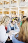 Woman with friends in library — Stock Photo