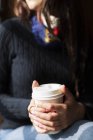 Jovem mulher segurando café descartável — Fotografia de Stock