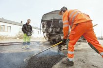 Trabajadores manuales pavimentación en la carretera - foto de stock