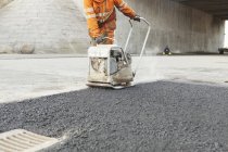 Ouvrier pose d'asphalte — Photo de stock