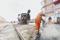 Trabalhador manual que estabelece asfalto — Fotografia de Stock