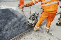 Trabalhador manual que estabelece asfalto — Fotografia de Stock