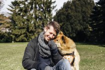 Man playing with Eurasier in park — Stock Photo