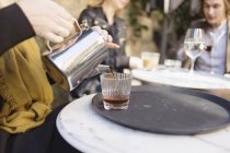 Donna versando caffè in vetro — Foto stock