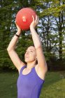 Женщина держит мяч в парке — стоковое фото