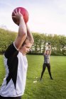 People exercising on grassy field at park — Stock Photo