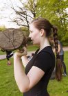 Woman holding log and exercising at park — Stock Photo