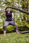 Mulher fazendo treinamento de corda no parque — Fotografia de Stock