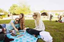 Счастливые друзья наслаждаются пикником в парке — стоковое фото