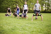 Friends assisting in performing push-ups — Stock Photo