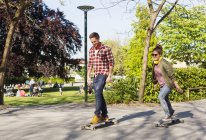 Happy couple skateboarding — Stock Photo