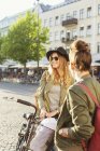Женщины с велосипедом стоят на улице — стоковое фото